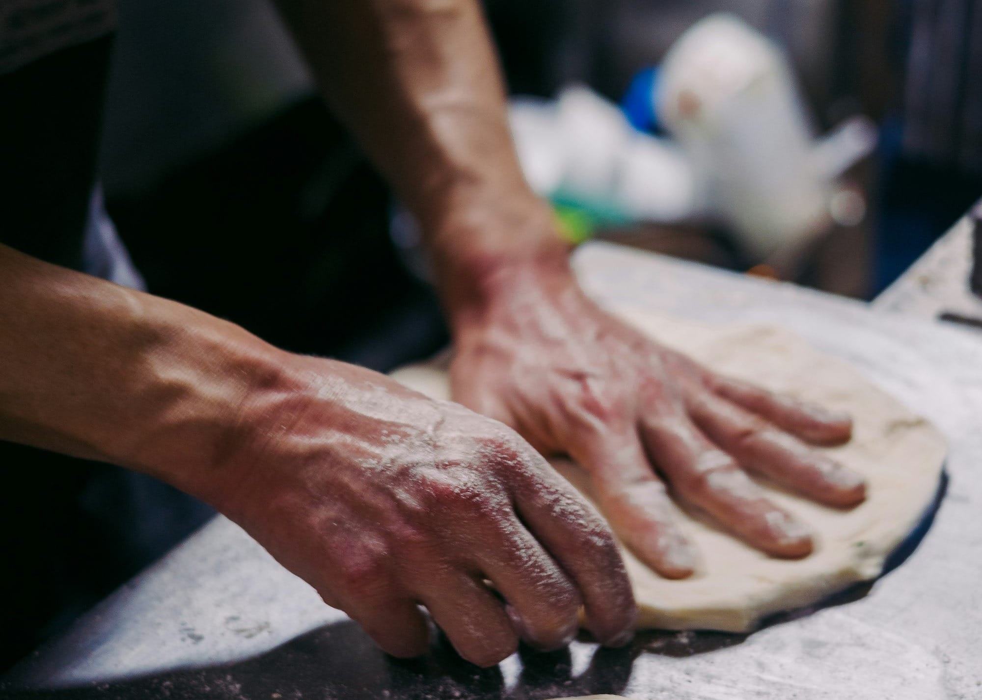 a person is kneading dough on a table